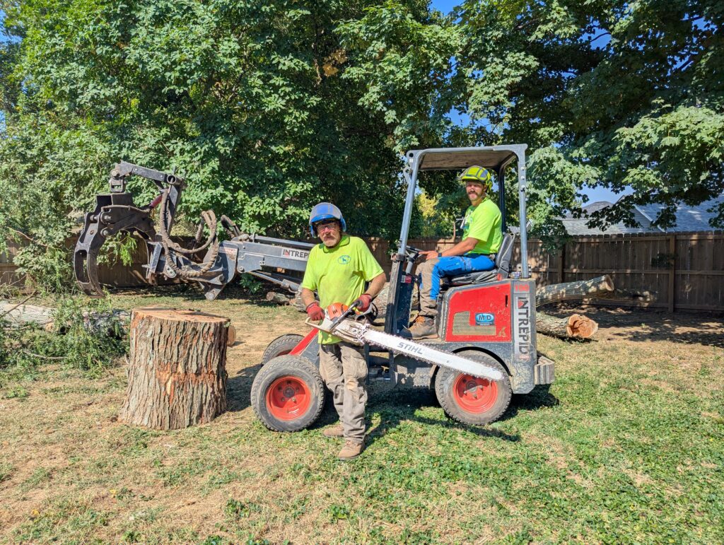 Beglian Tree Service with KM100 Tele and Branch Manager Grapple and posing with Stihl chainsaw with massive bar length